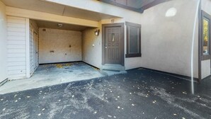 Um edifício com entrada de garagem, porta numerada e piso de concreto.