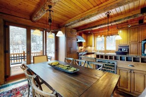 Ein Holzinterieur mit Esstisch, Stühlen und einer Küchenzeile.