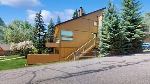 Un bâtiment moderne à deux étages, doté d’une façade en bois, d’un escalier et d’un balcon.