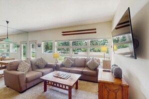 A living room with a sofa set, a coffee table, a lamp, and a television mounted on the wall. - Steps to Ski Shuttle Condo w/ Fireplace, WiFi & Shared Hot Tub/Seasonal Pool (Vail)