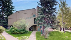 A building with a modern architectural style, a covered outdoor area, and a pathway leading to the entrance. - Adorable Condo in w/Shared Pool, Hot Tub, WiFi, Washer/Dryer, & Free Shuttle (Vail)