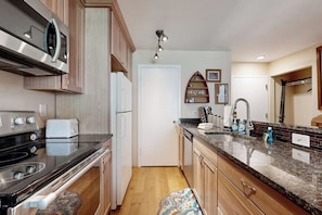 A kitchen with a stove, oven, microwave, and a sink with a countertop. - Adorable Condo in w/Shared Pool, Hot Tub, WiFi, Washer/Dryer, & Free Shuttle (Vail)