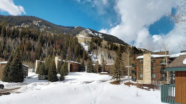 A snow-covered landscape with buildings, trees, and a mountain in the background. - Beautiful East Vail Condo w/ Vail Village Ski Lockers/Free WiFi/Near Ski Shuttle (Vail)