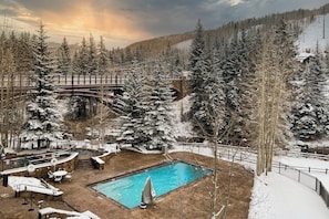 Ein Poolbereich mit Holzterrasse, Liegestühlen und einem kleinen Pool.