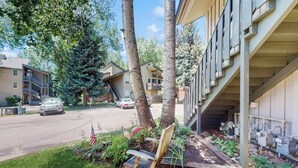A residential building with a covered outdoor area, a bench, and a flag. - Updated Condo with Walkable Locale, Free WiFi & Private Washer/Dryer (Vail)