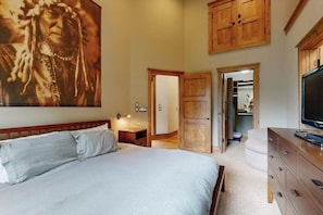 Ein Schlafzimmer mit einem großen Bett, einem Holzschrank und einem Fernseher.