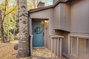 A house with a blue door, a small porch, and a tree in the foreground. - Charming home with private hot tub, fireplace, washer/dryer, and central AC (Vail)