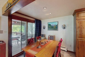 A dining area with a wooden table, chairs, and a view of the outdoors. - Charming home with private hot tub, fireplace, washer/dryer, and central AC (Vail)