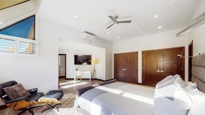 A modern bedroom with a large bed, a ceiling fan, and a view of the outdoors. - Three-story townhouse with balcony, mountain views, fireplace, grill, & W/D (Vail)