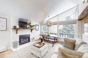 A living room with a fireplace, a dining table, and a sofa. - Cozy Condo walk to Lionshead, On Bus Route (Vail)