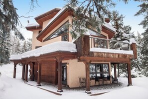 A two-story lodge with a balcony and a covered outdoor seating area. - Incredible 3BR mountain view -  steps to ski bus - fireplaces (Vail)