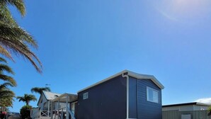 A single-story mobile home with a covered porch and a concrete driveway. - Morton A - Cabin with Views and Deck (Mollymook)