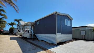 A single-story mobile home with a covered porch and a concrete driveway.