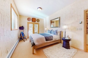 A bedroom with a bed, a chair, a mirror, and a lamp. - Secluded 3-story home with mountain views, fireplace, washer/dryer, & jetted tub (Vail)