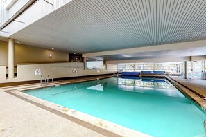 An indoor swimming pool with clear water, a tiled floor, and a ceiling with linear patterns. - Charming condo with resort amenities, sweeping views, & wood-burning fireplace (Vail)