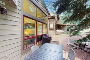 A wooden exterior with large windows, a patio table, and a covered grill area. - Comfortable home with fully stocked kitchen & W/D - great location (Vail)
