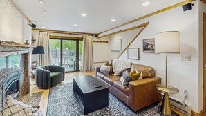 Una sala de estar moderna con chimenea, un sofá, una mesa de centro y una lámpara.