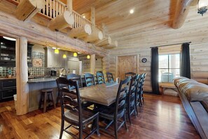 Ein Holzblockhaus-Interieur mit Essbereich, Küche und einer gemütlichen Sitzecke.