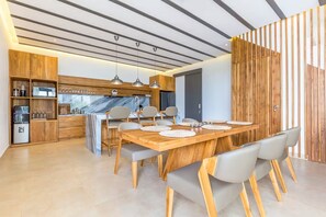 Eine moderne Küche mit Holzausstattung, einer Marmorarbeitsplatte und Pendelleuchten.
