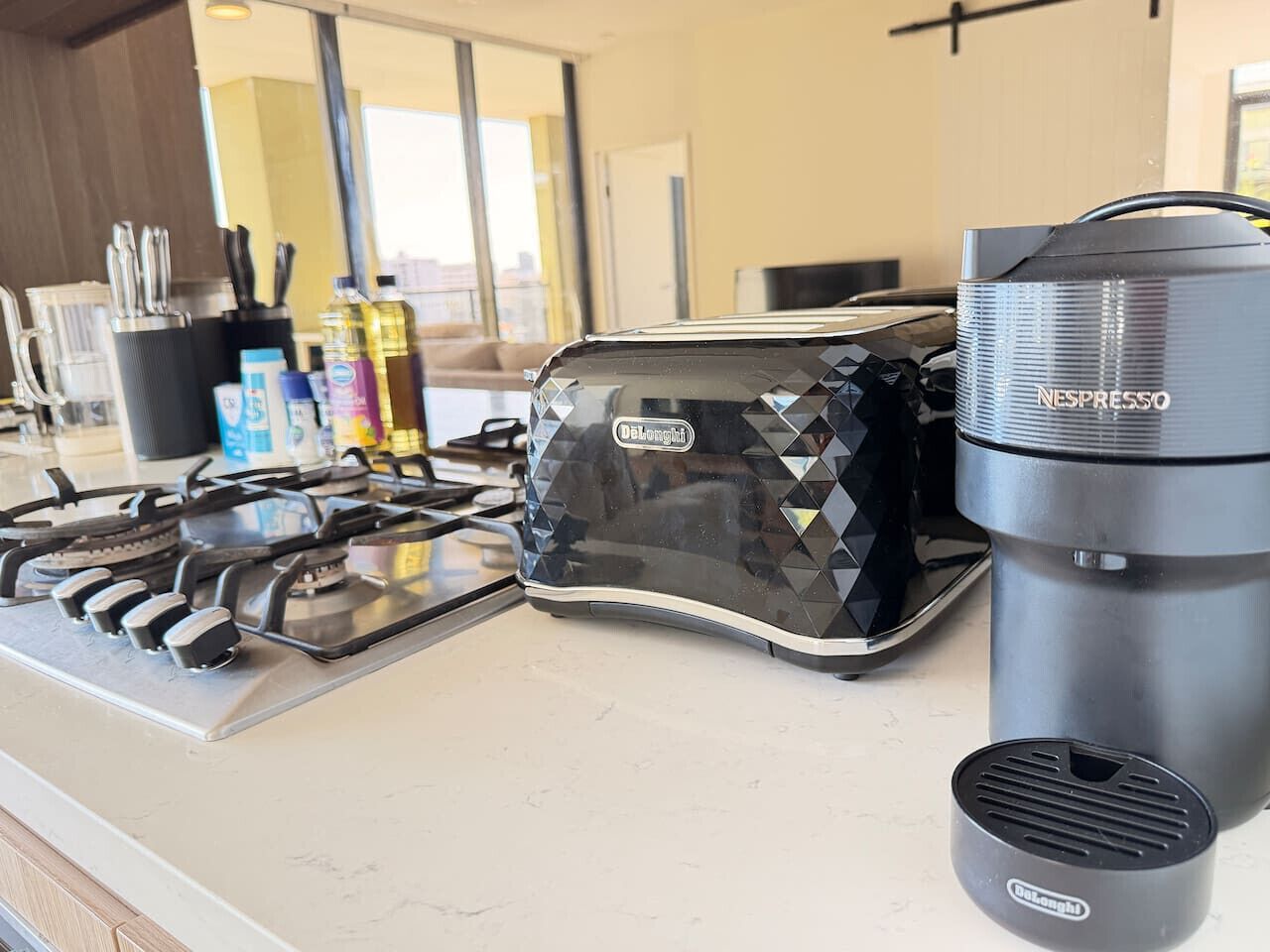 Une cuisine équipée d’une cuisinière à gaz, d’un grille-pain et d’une machine à café Nespresso.