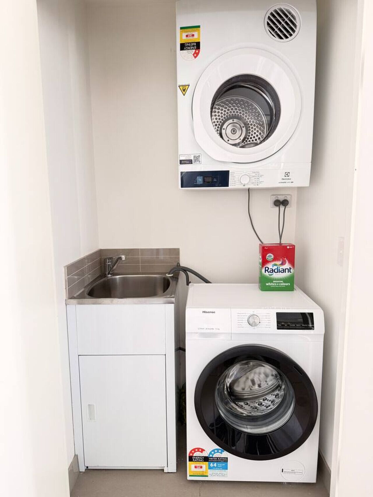 A compact laundry area with a washing machine and a sink.