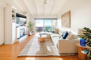 A modern living room with a sofa, coffee table, and a TV mounted on a wall.