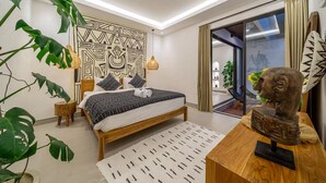 Un dormitorio moderno con cama, mesitas de noche, un papel tapiz estampado y vistas a través de un ventanal.