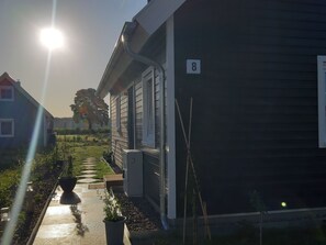 Ein Wohngebäude mit Hausnummer 8, einem Gartenweg und blauem Himmel.