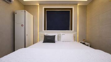 A hotel room with a bed, a nightstand, a phone, and a window with a view.