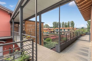 Ein Balkon mit Blick auf umliegende Häuser und Bäume.