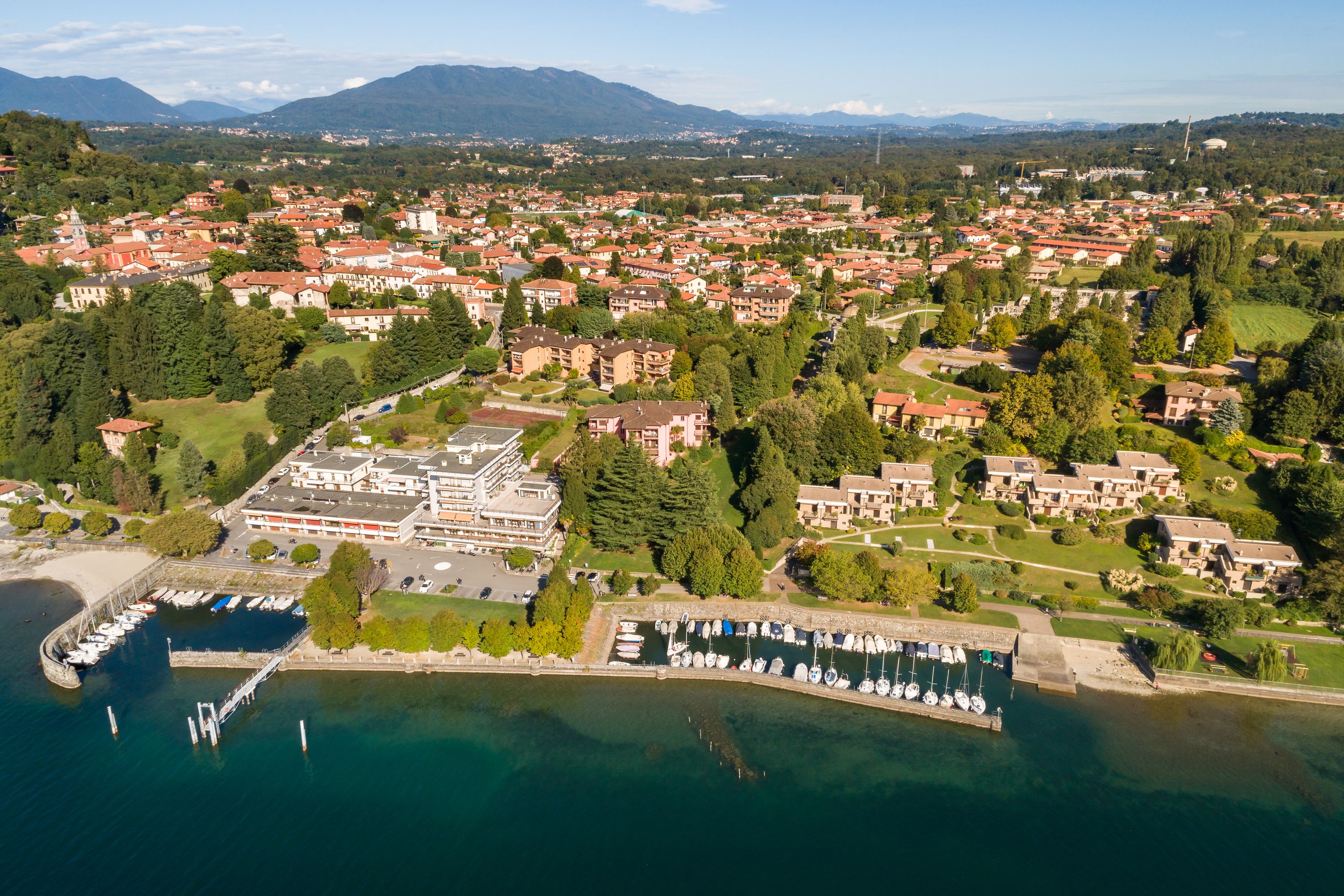 Vista aérea de un pueblo costero con un puerto deportivo, edificios residenciales y un gran complejo hotelero.