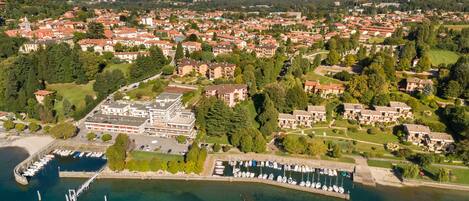 Vista aérea de un pueblo costero con un puerto deportivo, edificios residenciales y un gran complejo hotelero.