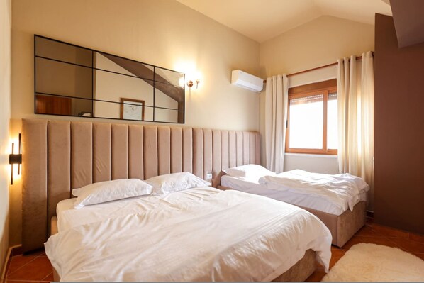 A bedroom with two beds, a large mirror, an air conditioning unit, and a window with curtains. - Rooftop Apartments 02 With Balcony Next to Fafa (Golem)