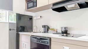 A modern kitchen with a built-in dishwasher, a microwave, and a coffee machine. - Newly Renovated Hotel - 2 Bedroom Suites with Kitchen in beautiful Columbia (Columbia)