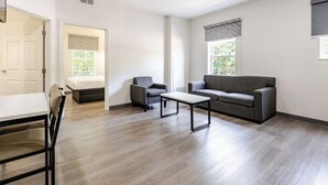 A modern living room with a sofa, armchair, and a small table. - Newly Renovated Hotel - 2 Bedroom Suites with Kitchen in beautiful Columbia (Columbia)