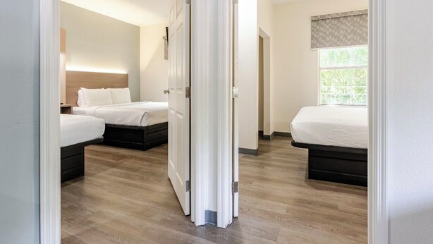 A hotel room with two beds, a large window, and a wooden floor. - Newly Renovated Hotel - 2 Bedroom Suites with Kitchen in beautiful Columbia (Columbia)