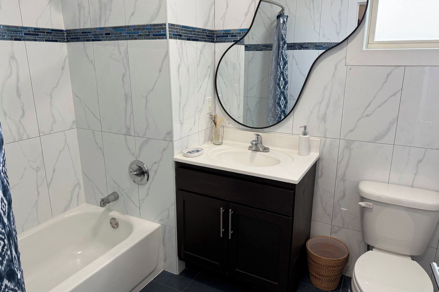 Un baño con bañera, lavabo, inodoro y espejo.