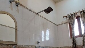 A bathroom with a ceiling fan, a mirror, a sink, and a mop. - KAPOOR SAHAB HOMESTAY it's a home away from home (Varanasi)