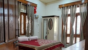 A bedroom with a bed, a wardrobe, a ceiling fan, and a marble floor. - KAPOOR SAHAB HOMESTAY it's a home away from home (Varanasi)
