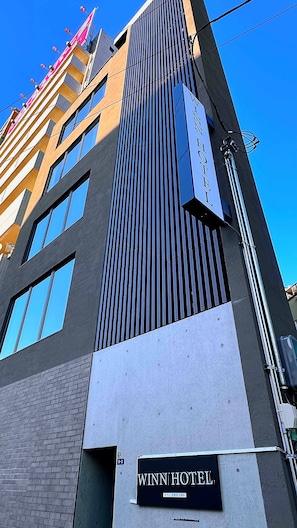A modern hotel building with a prominent sign reading 'WINN HOTEL.' - WINN hotel (Tokyo)