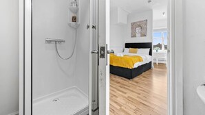 A modern bathroom with a glass shower enclosure, a visible toilet, and a white sink. - Comfort Studio Leeds Ideal for Work Study Street Parking (Leeds)