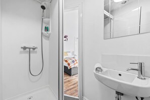 Ein modernes Badezimmer mit Dusche, Waschbecken und Spiegel.