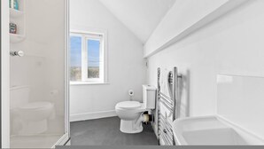 Un baño con inodoro, ventana y bañera.