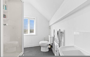 Ein Badezimmer mit Toilette, Fenster und Badewanne.