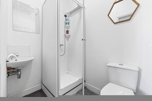 Ein Badezimmer mit Waschbecken, Toilette und Dusche.
