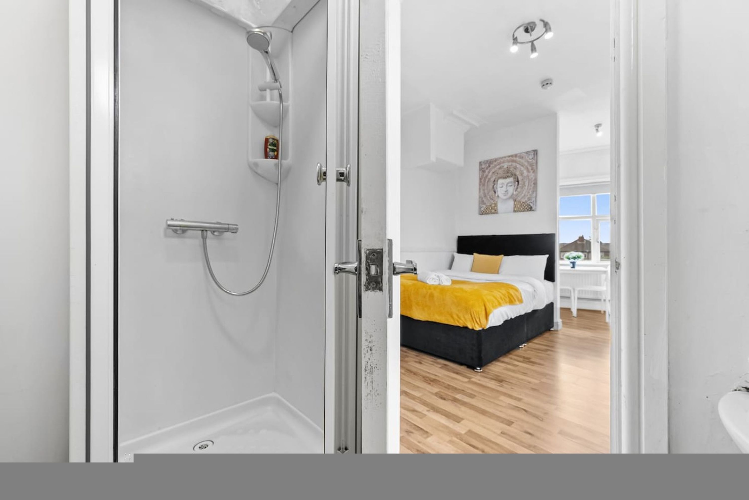 A modern bathroom with a glass shower enclosure, a visible toilet, and a white sink.