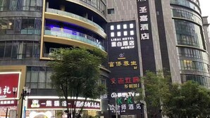 A modern hotel with a curved facade, large signage, and a prominent entrance. - K.K Fashion Hotel (Chongqing)