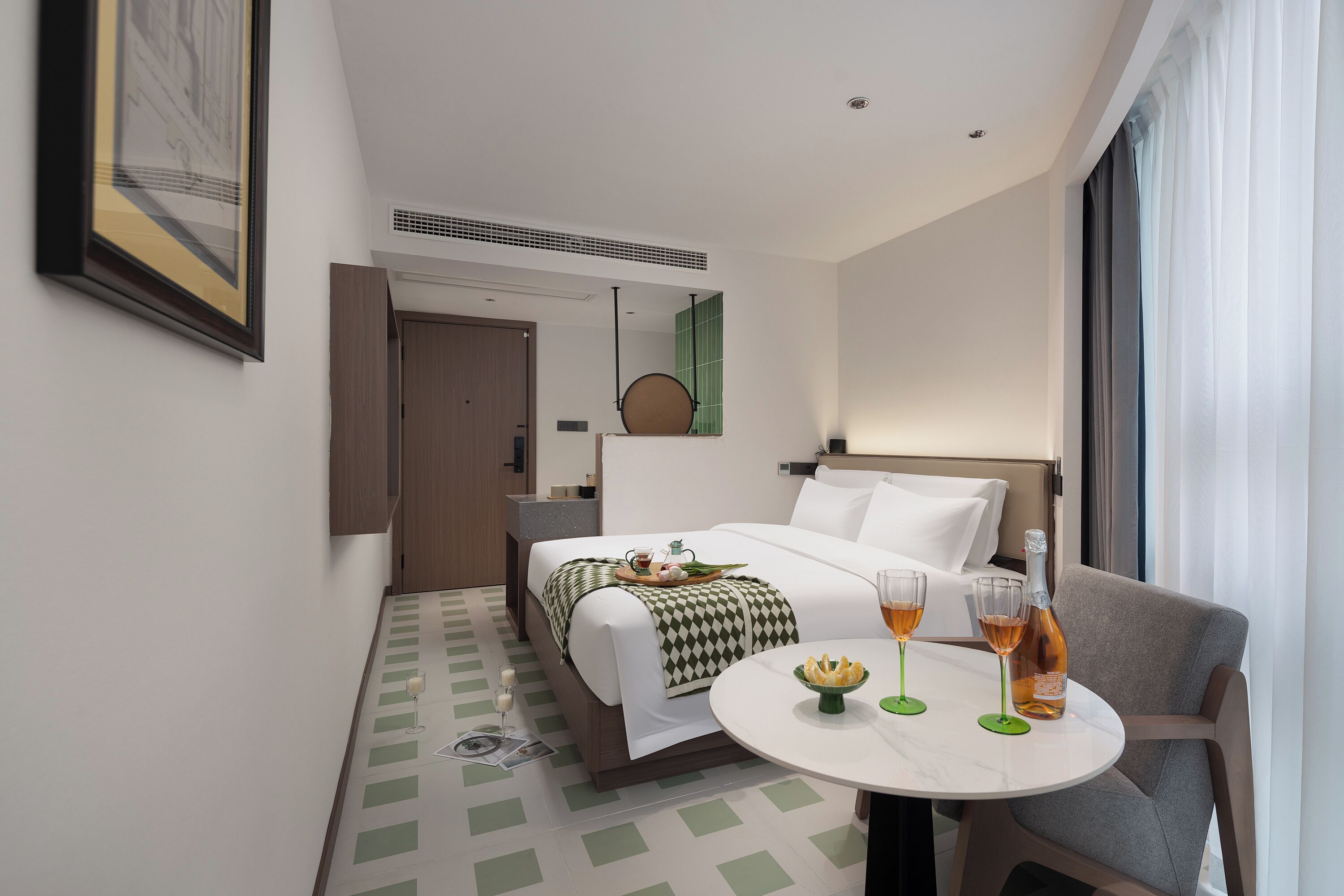 Una camera d'albergo con un letto, un comodino e un'area pranzo con tavolo e sedie.