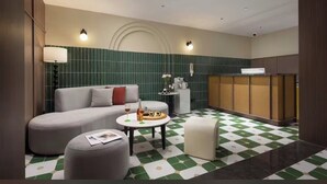 A modern hotel room with a sofa, a small round table, a coffee machine, and a cabinet. - K.K Fashion Hotel (Chongqing)