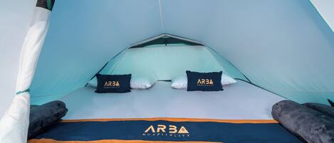 A tent with a logo, two pillows, and a blanket.